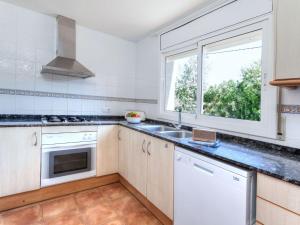 una cocina con electrodomésticos blancos y una ventana en Holiday Home Villa Santa Marta II by Interhome, en Les tres Cales