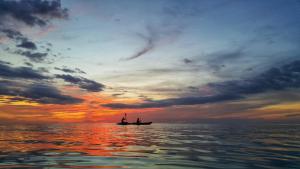 two people in a boat in the ocean at sunset at Latitude 26 Waterfront Boutique Resort - Bonita Springs in Bonita Springs