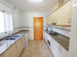 cocina con armarios blancos, fregadero y ventana en Villa Villa Sant Jordi by Interhome, en Les tres Cales