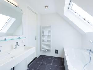 Un baño blanco con lavabo y espejo. en Holiday Home Alk 8-1 by Interhome, en Noordwijkerhout 11 fotos más