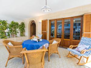 d'une terrasse avec une table et des chaises bleues. dans l'établissement Holiday Home Can Roses by Interhome, à Playa de Muro