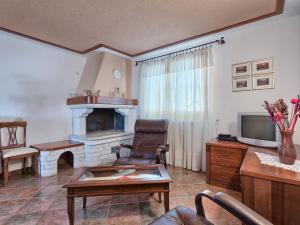 a living room with a fireplace and a chair at Holiday Home Istra by Interhome in Krnica