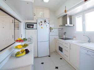 a kitchen with a white refrigerator and fruits on a counter at Apartment Les Roquetes by Interhome in Calpe