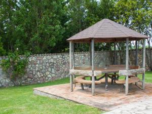 einen hölzernen Pavillon mit einem Tisch und Bänken in der Unterkunft Villa Olivo secolare by Interhome in Castelrinaldi