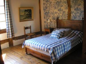 a bedroom with a bed and a chair in it at Holiday Home HOLLEBARDE in Léon