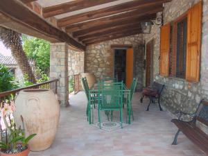 eine Terrasse mit einem Tisch und Stühlen auf einem Haus in der Unterkunft Villa Olivo secolare by Interhome in Castelrinaldi