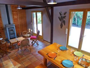 een eetkamer met tafels en stoelen en een open haard bij Holiday Home Lac et Forêt by Interhome in Le Moutchic