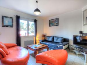 een woonkamer met een bank en een tv bij Holiday Home De la Plage by Interhome in Labenne