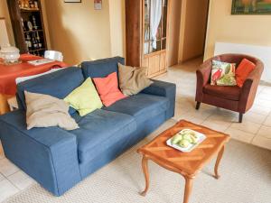 Holiday Home La Colinoise by Interhome في Coly: أريكة زرقاء في غرفة المعيشة مع طاولة