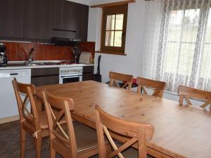 eine Küche mit einem Holztisch und Holzstühlen in der Unterkunft Apartment Brandegg 4 by Interhome in Lenk im Simmental