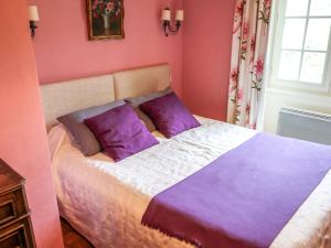 um quarto rosa com uma cama com almofadas roxas em Holiday Home La Colinoise by Interhome em Coly
