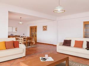 una sala de estar con 2 sofás blancos y una mesa. en Villa Casa da Horta by Interhome, en Estevais