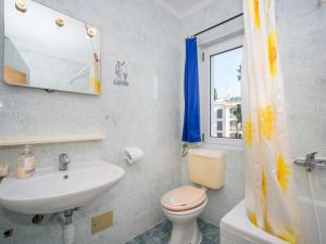 uma casa de banho com um lavatório, um WC e uma janela. em Apartment Hilde Blue-8 by Interhome em Medulin