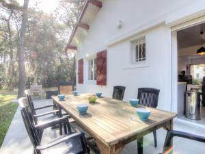 een houten tafel op de patio van een huis bij Holiday Home De la Plage by Interhome in Labenne