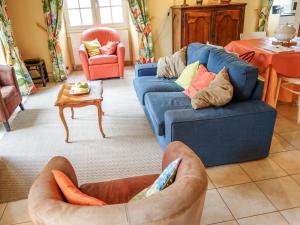 ein Wohnzimmer mit 2 blauen Sofas und einem Tisch in der Unterkunft Holiday Home La Colinoise by Interhome in Coly