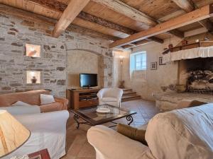 a living room with a couch and a tv at Villa Stancija Negrin by Interhome in Krnjaloža