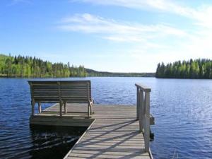 un banc assis sur un quai sur un lac dans l'établissement Holiday Home Pitkälahti by Interhome, à Vehmaskylä