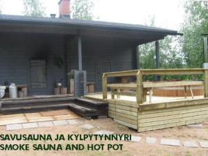 een huis met een veranda en een houten terras bij Holiday Home Honkaharju by Interhome in Petäjävesi