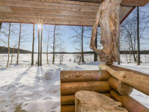 domek z bali w śniegu ze słońcem świecącym przez okno w obiekcie Holiday Home Hevonkuusi by Interhome w mieście Säkinmäki