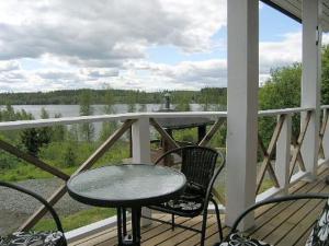 a table and chairs on a porch with a view of a lake at Holiday Home Mariantupa by Interhome in Muurame
