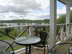 een tafel en stoelen op een veranda met uitzicht op een meer bij Holiday Home Mariantupa by Interhome in Muurame