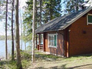 a small cabin in the woods next to a lake at Holiday Home Eteläranta by Interhome in Hara