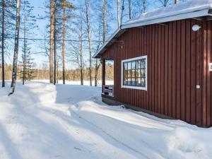 a small red building in the snow with trees at Holiday Home 2234 by Interhome in Savonranta