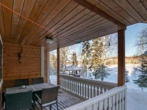 a wooden porch with a table and chairs on it at Holiday Home Aamunsarastus by Interhome in Savonranta