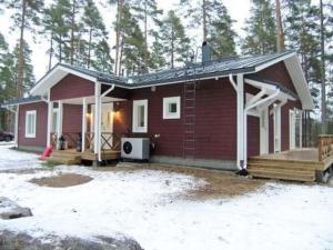 een klein rood huis met een veranda en een terras bij Holiday Home Ylä-hannala by Interhome in Muurame