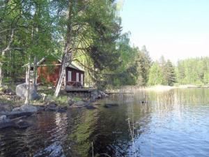 a small cabin on the shore of a lake at Holiday Home Hannala by Interhome in Muurame