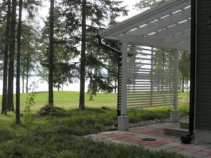 una pérgola blanca al lado de una casa en Holiday Home Paltamon golfhovi b by Interhome, en Paltamo