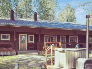 a wooden house with a porch and a yard at Holiday Home Villa kontio by Interhome in Savonranta