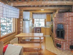 a kitchen with a table and a brick fireplace at Holiday Home Hepolehto by Interhome in Säkinmäki