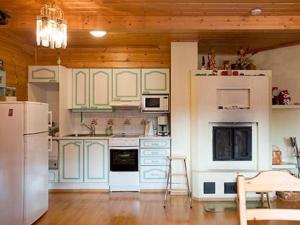 Holiday Home Lomatuuli by Interhome في Kello: مطبخ بأدوات بيضاء وسقف خشبي