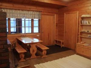 Habitación de madera con mesa, bancos y ventana en Holiday Home Aittoniemi i by Interhome, en Hopsu