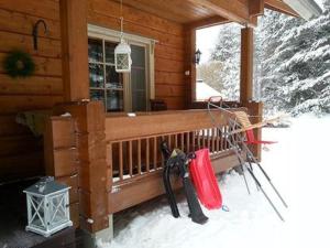 a porch of a cabin with snow and ski equipment at Holiday Home Honkaharju by Interhome in Petäjävesi +26 photos