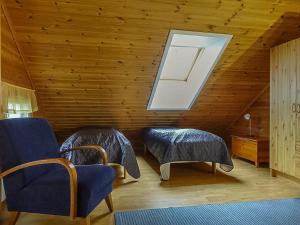 ein Dachzimmer mit zwei Stühlen und einem Dachfenster in der Unterkunft Holiday Home Aallotar havina by Interhome in Paltamo