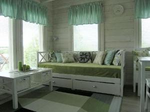 a bedroom with a bed and a table and windows at Holiday Home Mariantupa by Interhome in Muurame