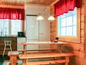 eine Küche mit einem Holztisch und einer Bank in der Unterkunft Holiday Home Käpälämäki by Interhome in Lahdenkylä