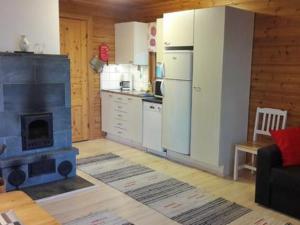 a kitchen with a fireplace and a stove in a room at Holiday Home Pihlajatupa by Interhome in Kittilä