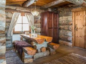a dining room with a table in a log cabin at Holiday Home Kopinkallio 3 by Interhome in Pätiälä