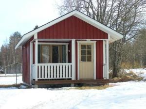 a small red and white shed in the snow at Holiday Home Karpalo by Interhome in Jokijärvi