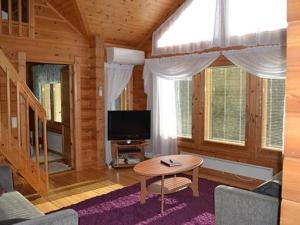 a living room with a table and a tv in a cabin at Holiday Home Vuoristomaja by Interhome in Kittilä