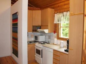 a kitchen with a white stove top oven next to a window at Holiday Home Keltavuokko by Interhome in Sipsiö