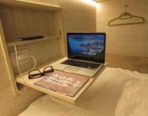 Vintage Bariloche Hostel Boutique في سان كارلوس دي باريلوتشي: وجود جهاز كمبيوتر محمول على طاولة في الغرفة