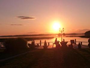 una persona seduta su una panchina a guardare il tramonto di Holiday Home Villa vuorikotka by Interhome a Kaivanto