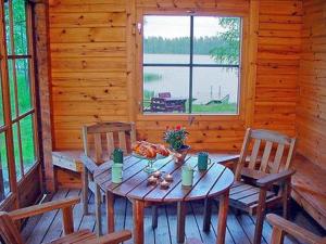 una mesa de madera y sillas en una cabaña en Holiday Home Joutsenlahti by Interhome, en Pätiälä