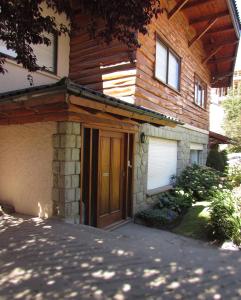 Vintage Bariloche Hostel Boutique في سان كارلوس دي باريلوتشي: منزل أمامه باب خشبي
