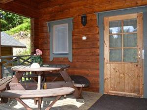 a wooden cabin with a table and a door at Holiday Home Rantamaja by Interhome in Kittilä