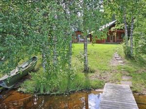 a boat sitting in the water next to a house at Holiday Home Rantatupa by Interhome in Hyyrylä